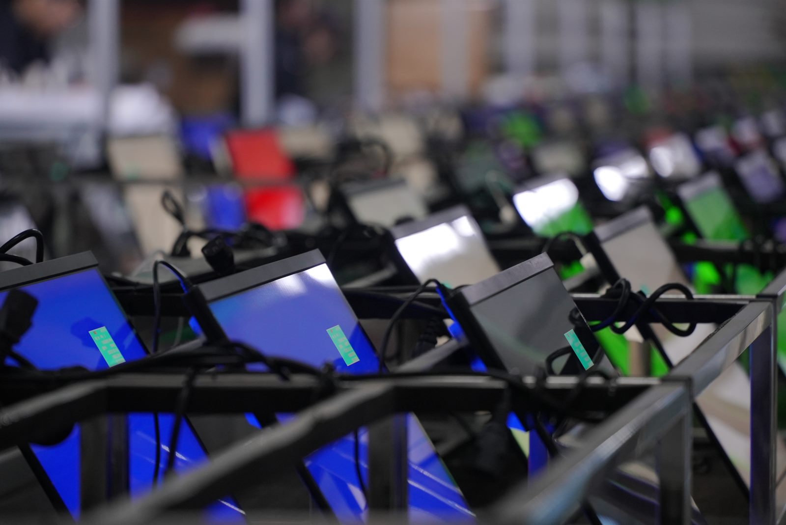 Rows of monitors running aging tests on a production line