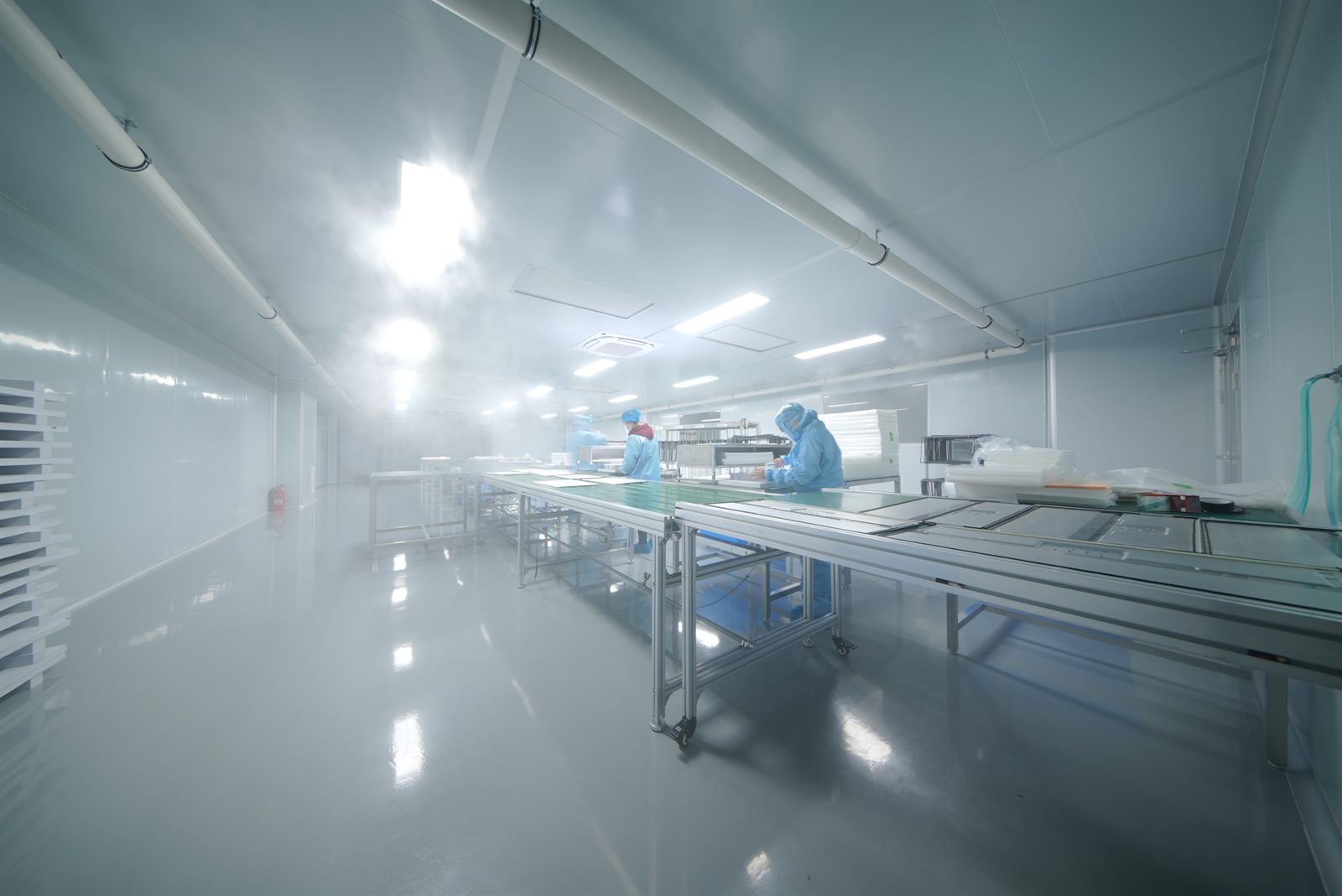 Clean-room production line with operators working on monitor panels