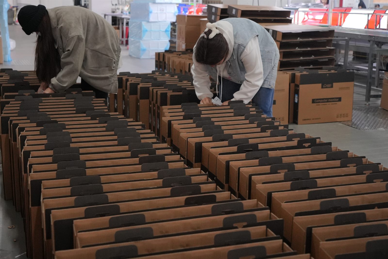 Workers checking monitor packaging cartons before shipment
