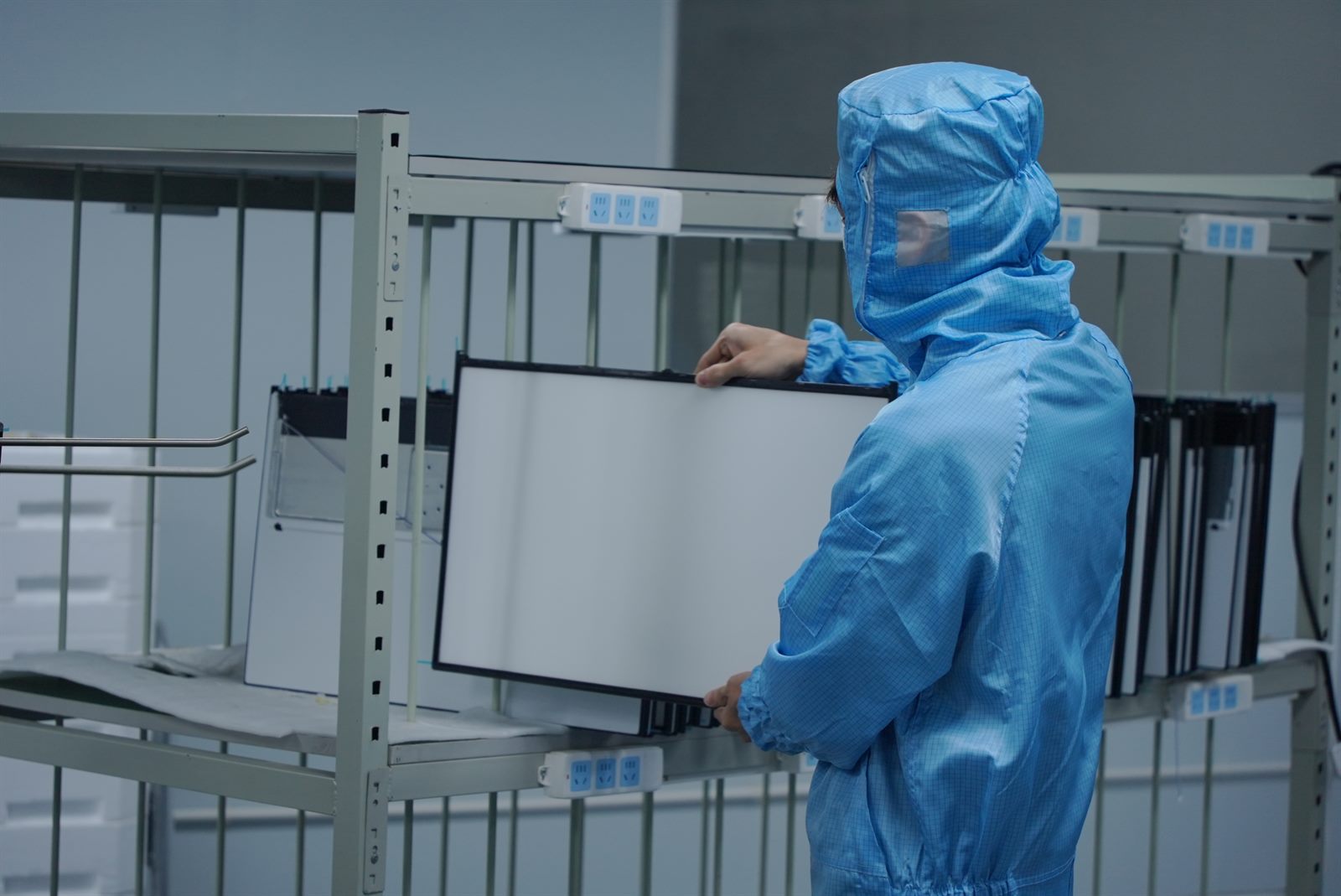 Operator placing monitor panels into a production rack